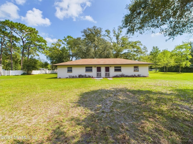 back of house with fence and a yard