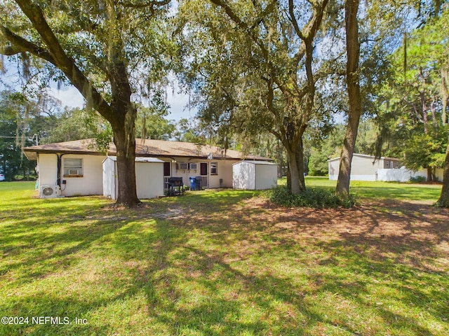 view of yard featuring an outbuilding, a storage unit, and ac unit