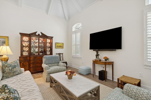 1505 Lakeside Ct, Fernandina Beach, FL 32034 - living room featuring high vaulted ceiling, baseboards, beamed ceiling, and light wood-type flooring