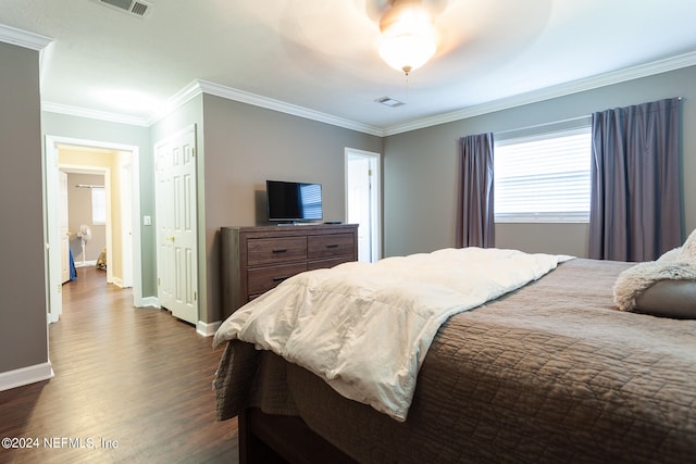 bedroom featuring dark hardwood / wood-style floors, ceiling fan, ornamental molding, and a closet