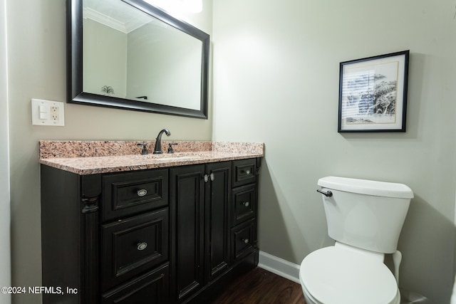 bathroom featuring hardwood / wood-style floors, vanity, toilet, and crown molding