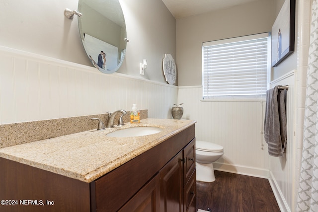 bathroom featuring wood-type flooring, vanity, and toilet