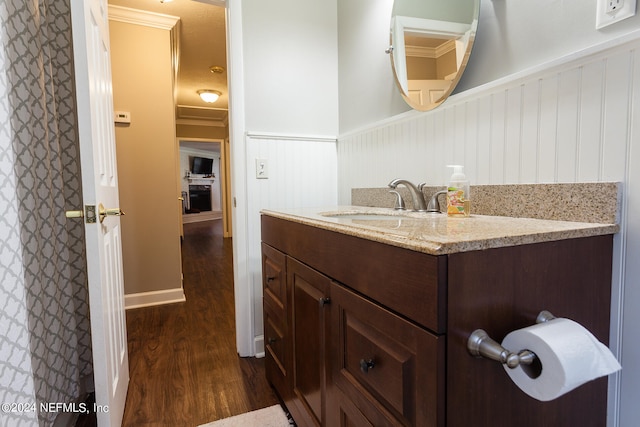 bathroom featuring vanity, wood-type flooring, and crown molding