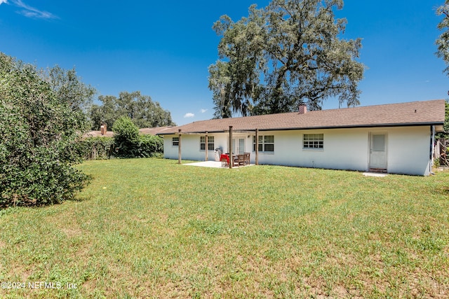 back of property featuring a yard and a patio area