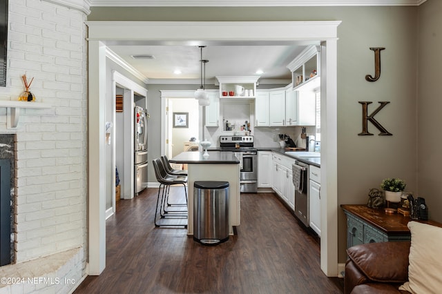 kitchen with pendant lighting, a breakfast bar, dark hardwood / wood-style flooring, white cabinetry, and stainless steel appliances