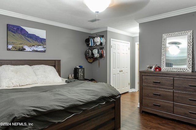 bedroom with dark hardwood / wood-style floors, ceiling fan, crown molding, and a closet