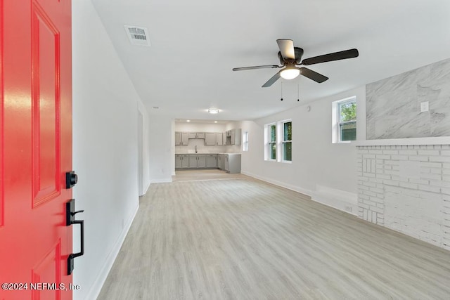 unfurnished living room featuring ceiling fan and light hardwood / wood-style floors