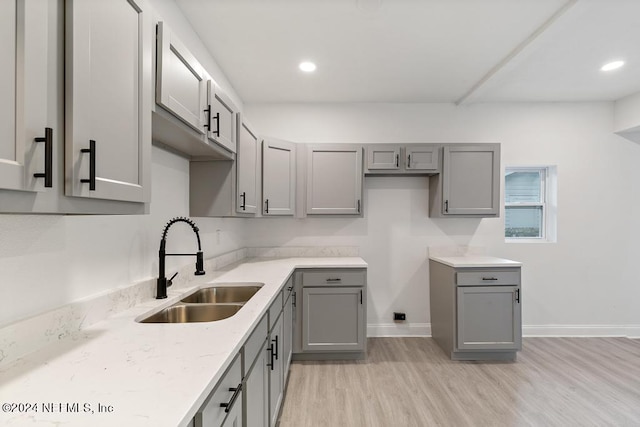 kitchen featuring light wood-type flooring, sink, and gray cabinetry