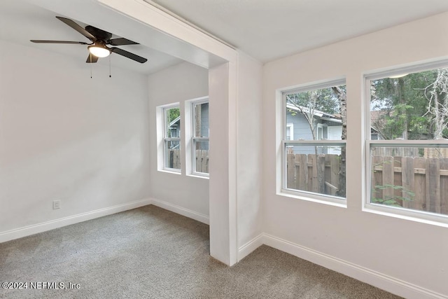 empty room with carpet flooring, ceiling fan, and a healthy amount of sunlight