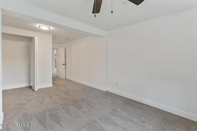 unfurnished bedroom with ceiling fan, light colored carpet, and a closet