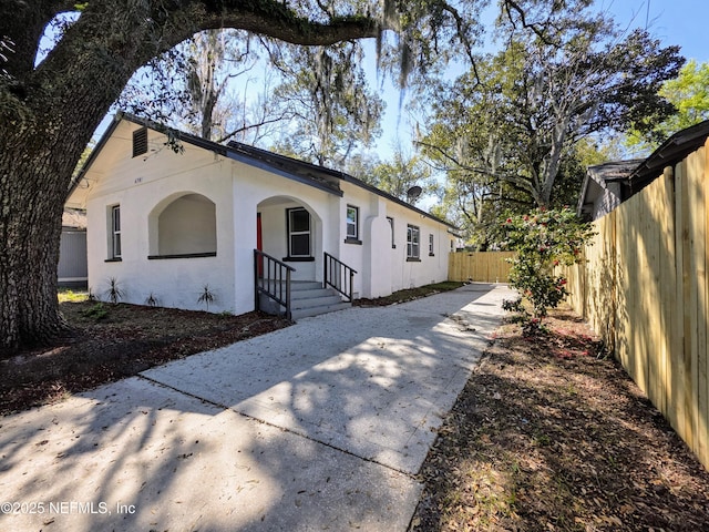 view of front of house with fence and stucco siding