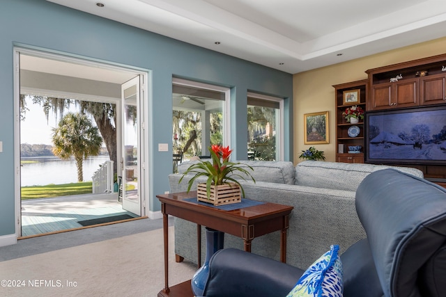 carpeted living room with a wealth of natural light and a water view