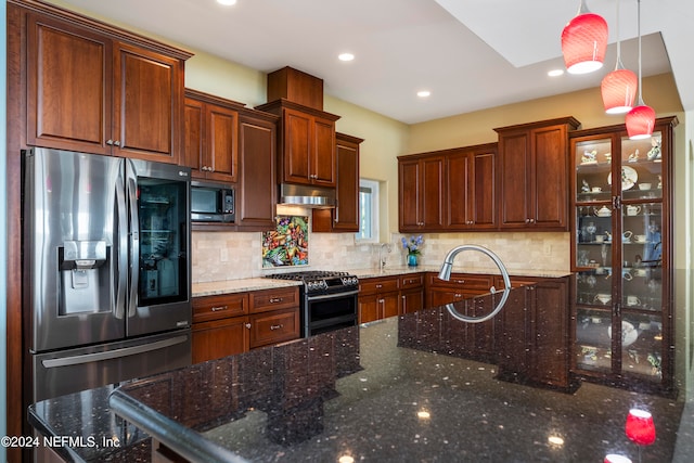 kitchen with black range with gas stovetop, stainless steel fridge, dark stone counters, pendant lighting, and built in microwave