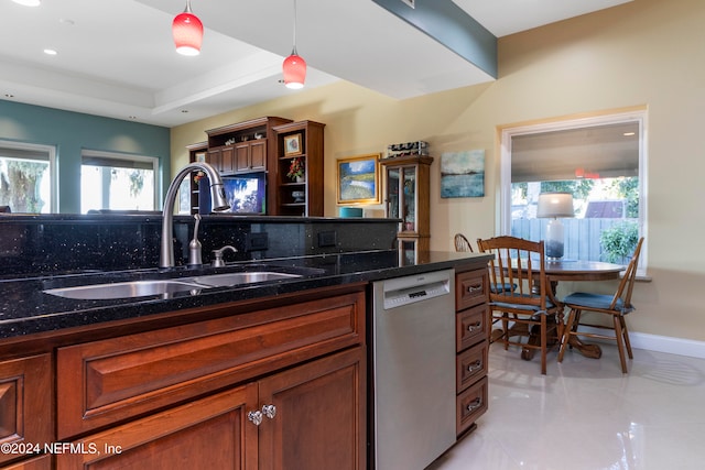 kitchen with sink, dark stone counters, decorative light fixtures, stainless steel dishwasher, and decorative backsplash