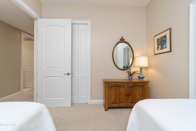 bedroom featuring light colored carpet and a closet