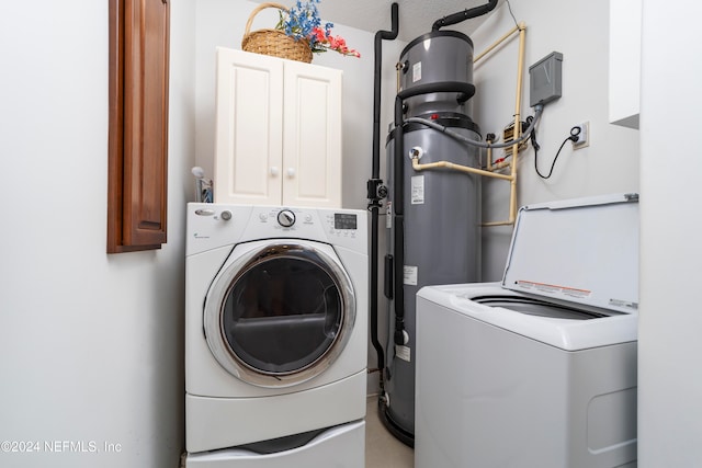 laundry room with a textured ceiling, cabinets, and separate washer and dryer