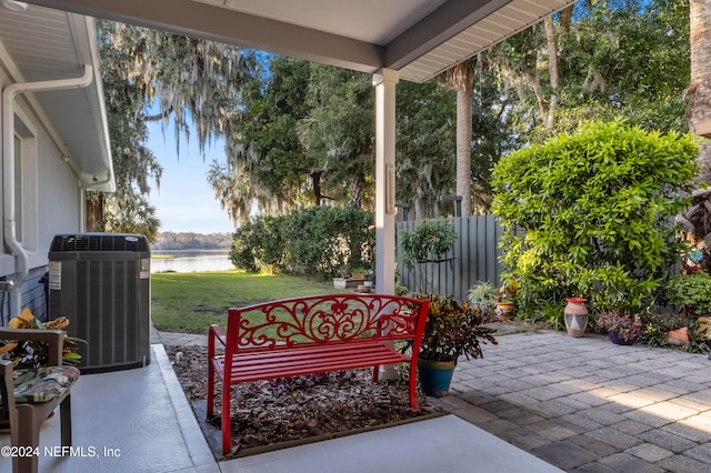 view of patio / terrace with central air condition unit and a water view