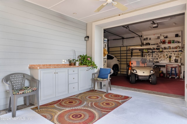 garage featuring wooden walls and ceiling fan