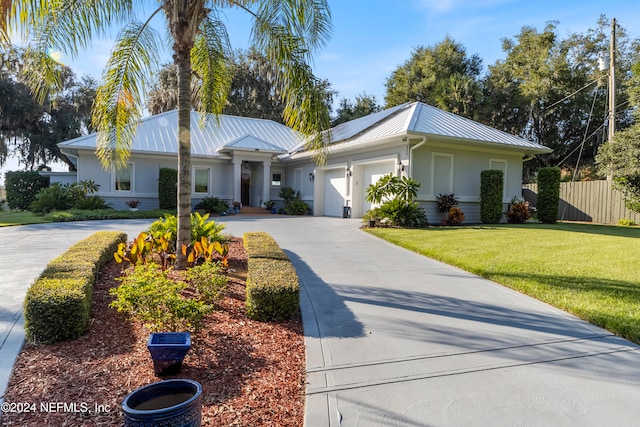 ranch-style house featuring a front yard and a garage