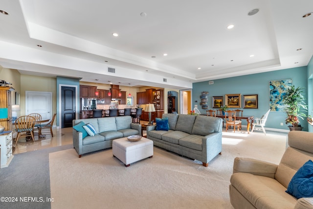 living room with light colored carpet and a raised ceiling