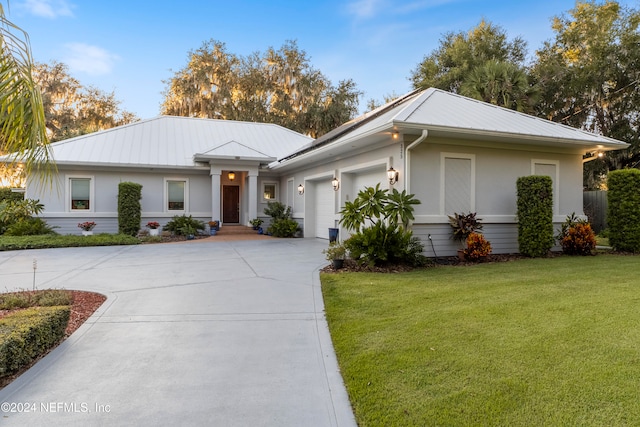 ranch-style home featuring a front yard and a garage