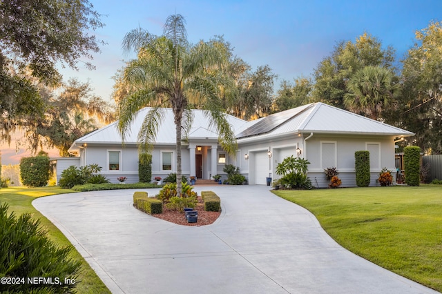 view of front of property featuring a garage and a lawn