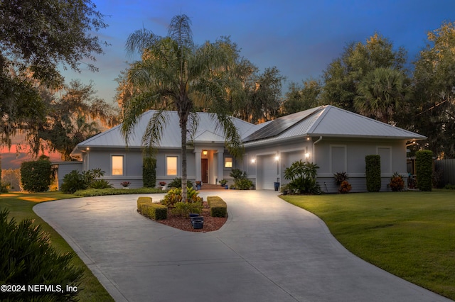 view of front facade with a garage and a lawn