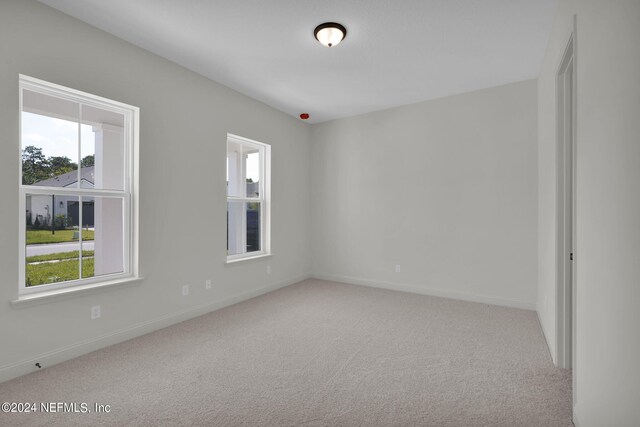 unfurnished room featuring light colored carpet