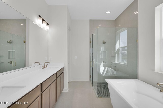 bathroom with shower with separate bathtub, a healthy amount of sunlight, vanity, and tile patterned floors