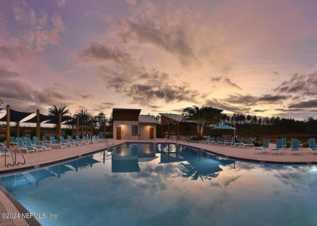 pool at dusk with a patio