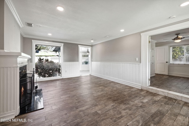 unfurnished living room featuring ceiling fan, ornamental molding, and dark hardwood / wood-style flooring