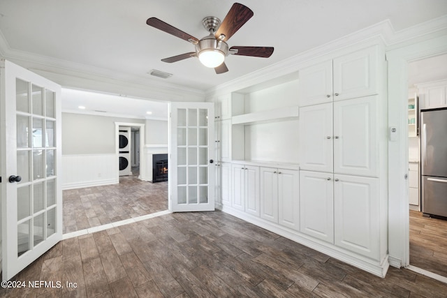 interior space with french doors, stacked washer and clothes dryer, crown molding, and dark wood-type flooring