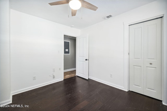 unfurnished bedroom with ceiling fan, dark hardwood / wood-style flooring, and a closet