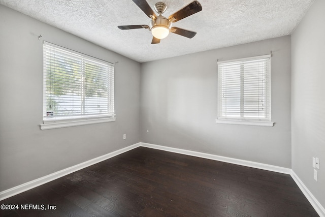 spare room with a textured ceiling, dark hardwood / wood-style floors, and ceiling fan