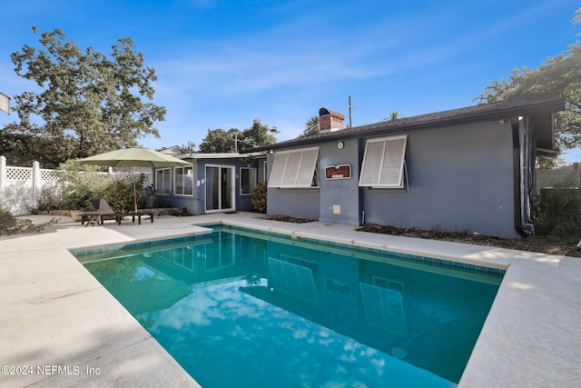 back of property featuring a fenced in pool