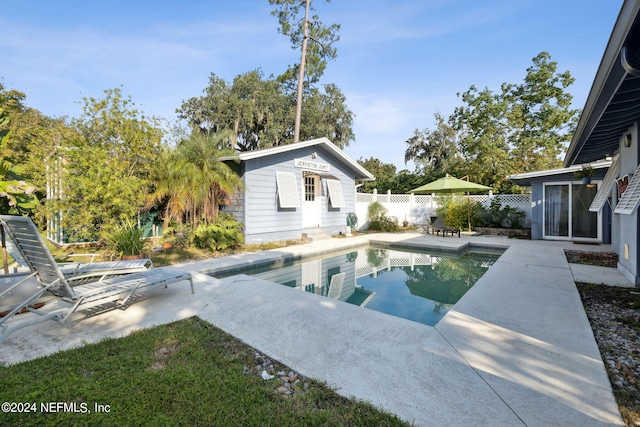 view of pool with an outbuilding and a patio area