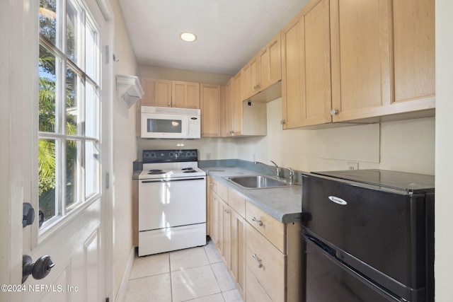 kitchen with sink, white appliances, light tile patterned flooring, and light brown cabinets