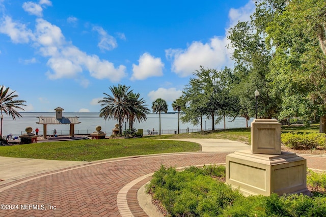 view of property's community with a yard and a water view