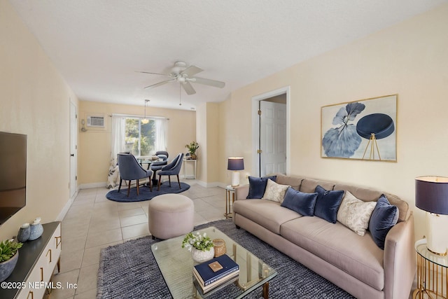 tiled living room featuring an AC wall unit and ceiling fan