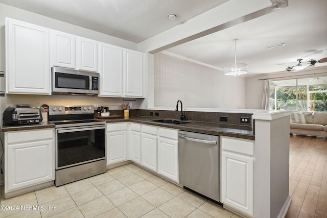 kitchen featuring sink, kitchen peninsula, light hardwood / wood-style flooring, white cabinetry, and appliances with stainless steel finishes