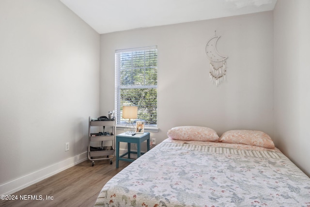 bedroom with wood-type flooring and lofted ceiling