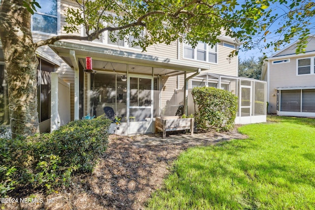 back of house with a yard and a sunroom