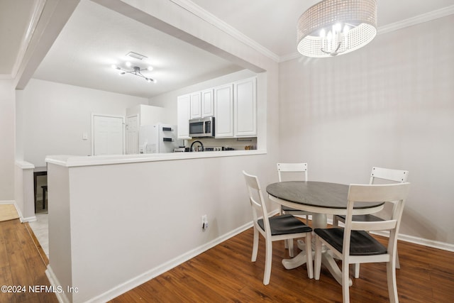 dining space featuring wood-type flooring, an inviting chandelier, and crown molding