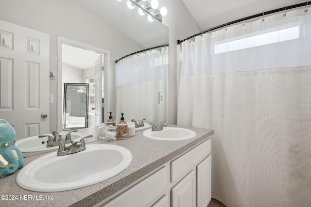 bathroom with a shower with shower curtain, vaulted ceiling, and vanity