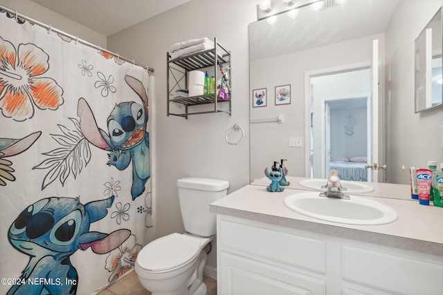 bathroom featuring a shower with curtain, vanity, tile patterned flooring, and toilet