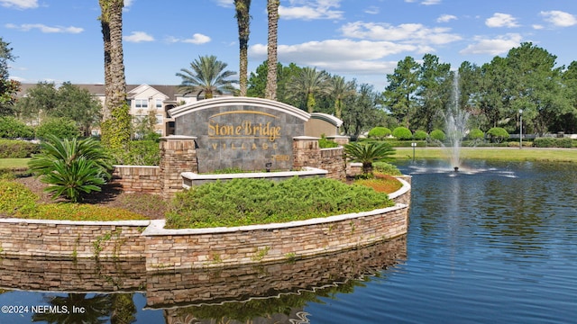 community / neighborhood sign with a water view