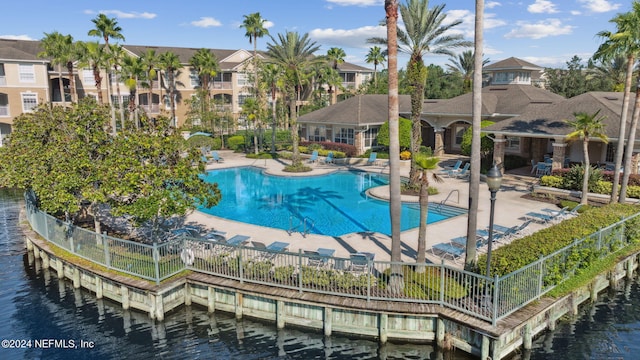 view of swimming pool featuring a patio and a water view