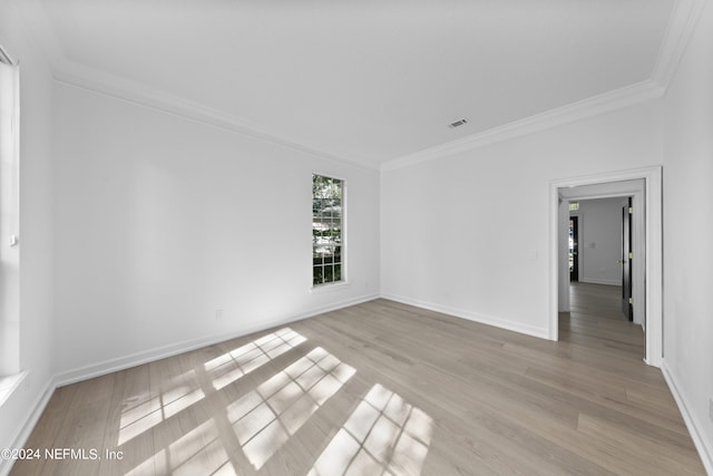 empty room featuring crown molding and light hardwood / wood-style floors