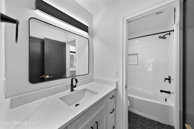 full bathroom with vanity, toilet, a textured ceiling, and tiled shower / bath