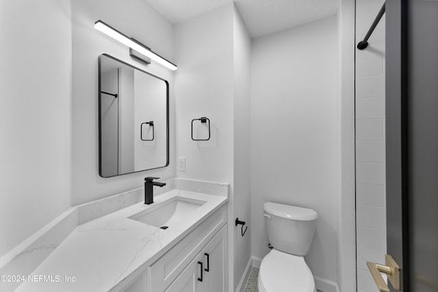 bathroom featuring toilet, walk in shower, and vanity